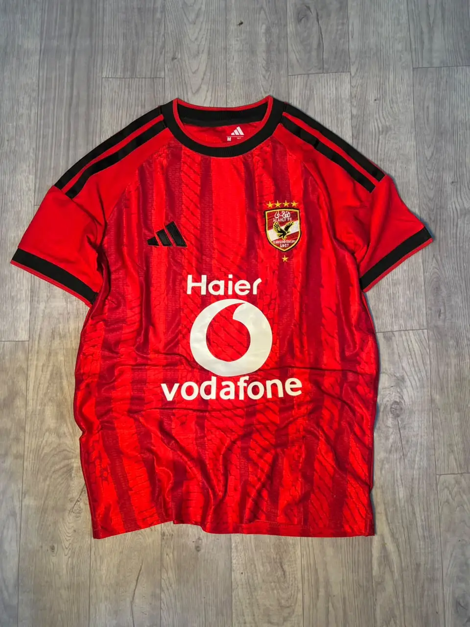 قميص الأهلي الأساسي 2026/27 بشعارات تطريز (عرض)